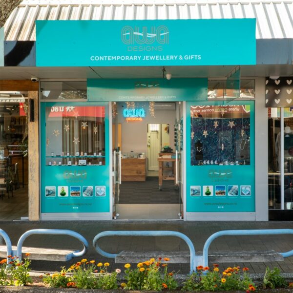 Awa Designs store front in teal colours with window display of NZ souviners and genuinie greenstone pounamu