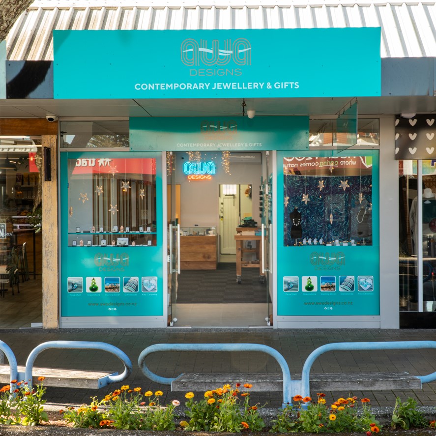 Awa Designs store front in teal colours with window display of NZ souviners and genuinie greenstone pounamu